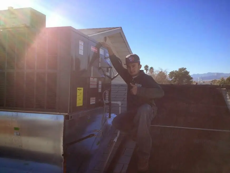 HVAC technician performing Boiler Repair on a rooftop unit in Granby